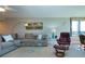 Open living space featuring a gray sectional, contemporary decor, and a large window overlooking the scenery at 5750 Midnight Pass Rd # 203, Sarasota, FL 34242