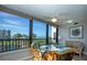 Sun room seating area with ceiling fan, floor to ceiling windows with views of the ocean and beach at 5750 Midnight Pass Rd # 203, Sarasota, FL 34242