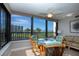Sun room seating area with ceiling fan, floor to ceiling windows with views of the ocean and beach at 5750 Midnight Pass Rd # 203, Sarasota, FL 34242