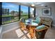 Bright sunroom with wicker furniture enjoys picturesque views of the pool and landscaping through large sliding glass windows at 5750 Midnight Pass Rd # 203, Sarasota, FL 34242