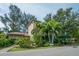 A charming clubhouse and office building with lush tropical landscaping and a welcoming entrance at 5880 Midnight Pass Rd # 202, Sarasota, FL 34242