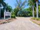 Welcoming entrance to Casarina community with well-maintained landscaping and a brick paved driveway at 5880 Midnight Pass Rd # 202, Sarasota, FL 34242