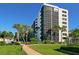 Modern condo building with lush landscaping, brick path and community pool at 5880 Midnight Pass Rd # 202, Sarasota, FL 34242