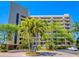 Modern condo building featuring lush greenery and well-maintained exterior, with a circular driveway and ample parking at 5880 Midnight Pass Rd # 202, Sarasota, FL 34242