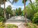 Outdoor patio with seating and dining areas surrounded by lush greenery at 5880 Midnight Pass Rd # 202, Sarasota, FL 34242