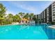 Resort style pool with cabanas, chairs and tropical landscaping at 5880 Midnight Pass Rd # 202, Sarasota, FL 34242
