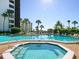Resort style pool and spa surrounded by lounge chairs and palm trees at 5880 Midnight Pass Rd # 202, Sarasota, FL 34242