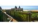 Wooden walkway with lush greenery leads to a tranquil beach with lounge chairs at 5880 Midnight Pass Rd # 202, Sarasota, FL 34242