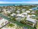 Stunning aerial view of a luxurious waterfront home with private dock and turquoise pool at 590 De Narvaez Dr, Longboat Key, FL 34228