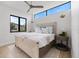 Modern bedroom with a cozy bed, side tables, contemporary lighting, and an exterior view at 590 De Narvaez Dr, Longboat Key, FL 34228