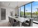Elegant dining area with a large table, comfortable seating, and scenic views from the expansive floor-to-ceiling windows at 590 De Narvaez Dr, Longboat Key, FL 34228