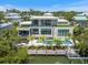 Modern home features a private pool, a lush outdoor area, and a boat dock on the water at 590 De Narvaez Dr, Longboat Key, FL 34228