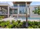 Stunning exterior view of modern home with a backyard oasis and an outdoor kitchen at 590 De Narvaez Dr, Longboat Key, FL 34228
