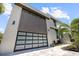 Contemporary home showcasing a sleek glass garage door, clean lines, and modern architectural details at 590 De Narvaez Dr, Longboat Key, FL 34228