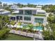 Modern home with a pool, dock, and lush landscaping, perfect for waterfront living at 590 De Narvaez Dr, Longboat Key, FL 34228