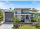 Modern home exterior with stone accents, well-manicured landscaping, and an attached garage at 590 De Narvaez Dr, Longboat Key, FL 34228