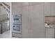 Modern kitchen with built-in double ovens, a refrigerator with matching panels, and sleek cabinets with long, minimalist handles at 590 De Narvaez Dr, Longboat Key, FL 34228