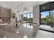 Modern kitchen island with granite countertop, stylish pendant lights, and sliding glass doors to the outdoor balcony at 590 De Narvaez Dr, Longboat Key, FL 34228