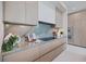 Gourmet kitchen featuring sleek cabinetry, stone backsplash, modern appliances, and integrated lighting for a sophisticated cooking space at 590 De Narvaez Dr, Longboat Key, FL 34228