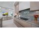 Open-concept kitchen with stylish cabinets, stone backsplash, and seamless flow to the living area for easy entertaining at 590 De Narvaez Dr, Longboat Key, FL 34228