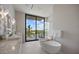 This bathroom has double sinks, a modern soaking tub, and an expansive window overlooking the tropical scenery at 590 De Narvaez Dr, Longboat Key, FL 34228