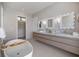 This bathroom features a soaking tub, closet access, and double sinks with a marble countertop at 590 De Narvaez Dr, Longboat Key, FL 34228