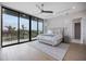 This bedroom has a large king bed, ceiling fan, and a wall of glass that looks out to an expansive view at 590 De Narvaez Dr, Longboat Key, FL 34228