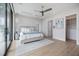 This bedroom features a ceiling fan, white walls, a walk-in closet, and a king bed with stylish linens at 590 De Narvaez Dr, Longboat Key, FL 34228