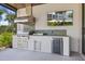 Outdoor kitchen featuring a built-in grill, refrigerator, and counter space for entertaining at 590 De Narvaez Dr, Longboat Key, FL 34228