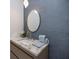 Well-appointed powder room with textured wall, a pendant light, and a round mirror at 590 De Narvaez Dr, Longboat Key, FL 34228