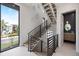 Staircase with modern railings, adjacent to a room with a sophisticated powder room at 590 De Narvaez Dr, Longboat Key, FL 34228