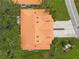 Birds eye view of terra cotta tile roof, driveway, and surrounding trees and green lawn at 6755 Approach Rd # 31, Sarasota, FL 34238