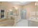 Spacious bathroom with double vanity sinks, a soaking tub, and glass-enclosed shower at 6755 Approach Rd # 31, Sarasota, FL 34238