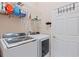 Modern laundry room with large washer and dryer and storage shelf at 6755 Approach Rd # 31, Sarasota, FL 34238