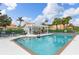 Community pool with clear water, lounge chairs, tables, and shaded gazebo at 6755 Approach Rd # 31, Sarasota, FL 34238