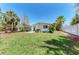 Spacious backyard with lush green grass, a patio area, and mature trees at 681 Fox St, Longboat Key, FL 34228