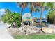 Welcoming entrance sign surrounded by lush greenery and palm trees, creating a tropical ambiance at 681 Fox St, Longboat Key, FL 34228