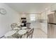 Bright eat-in kitchen featuring white cabinetry, appliances, and a charming breakfast nook at 681 Fox St, Longboat Key, FL 34228