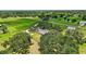Expansive aerial view of a lush estate featuring a home, barn, and fenced pastures, blending nature and comfort at 6875 Myakka Valley Trl, Sarasota, FL 34241