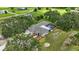 Aerial view of a home with an enclosed pool, surrounded by lush greenery and expansive pastures at 6875 Myakka Valley Trl, Sarasota, FL 34241