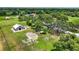 Aerial view showcasing the property, barn, and green pastures surrounded by mature trees at 6875 Myakka Valley Trl, Sarasota, FL 34241