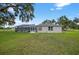 Charming home featuring a lovely, well-maintained backyard with lush green grass and a lovely screened-in lanai at 6875 Myakka Valley Trl, Sarasota, FL 34241