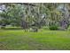 Backyard firepit area with Adirondack chairs, mature trees, and a volleyball net at 6875 Myakka Valley Trl, Sarasota, FL 34241