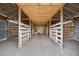 Barn interior with wooden stalls, dirt floor, and sturdy beams, suitable for livestock or equipment at 6875 Myakka Valley Trl, Sarasota, FL 34241