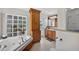 Bright bathroom features a soaking tub, glass block window, wooden vanity, and tile flooring at 6875 Myakka Valley Trl, Sarasota, FL 34241