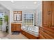 Bathroom featuring a soaking tub with glass block window, wooden vanity, and tile flooring at 6875 Myakka Valley Trl, Sarasota, FL 34241