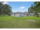 Spacious home exterior with lush green lawn, mature trees, and outdoor equipment, ideal for a rural setting at 6875 Myakka Valley Trl, Sarasota, FL 34241