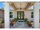 Covered front entry with decorative glass doors and meticulously manicured landscaping creates a welcoming atmosphere at 6875 Myakka Valley Trl, Sarasota, FL 34241