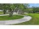 Charming single-story home with a circular driveway and lush landscaping, complete with a whimsical tree swing at 6875 Myakka Valley Trl, Sarasota, FL 34241