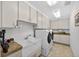 Well-organized laundry room with ample storage and a modern washer/dryer at 6875 Myakka Valley Trl, Sarasota, FL 34241